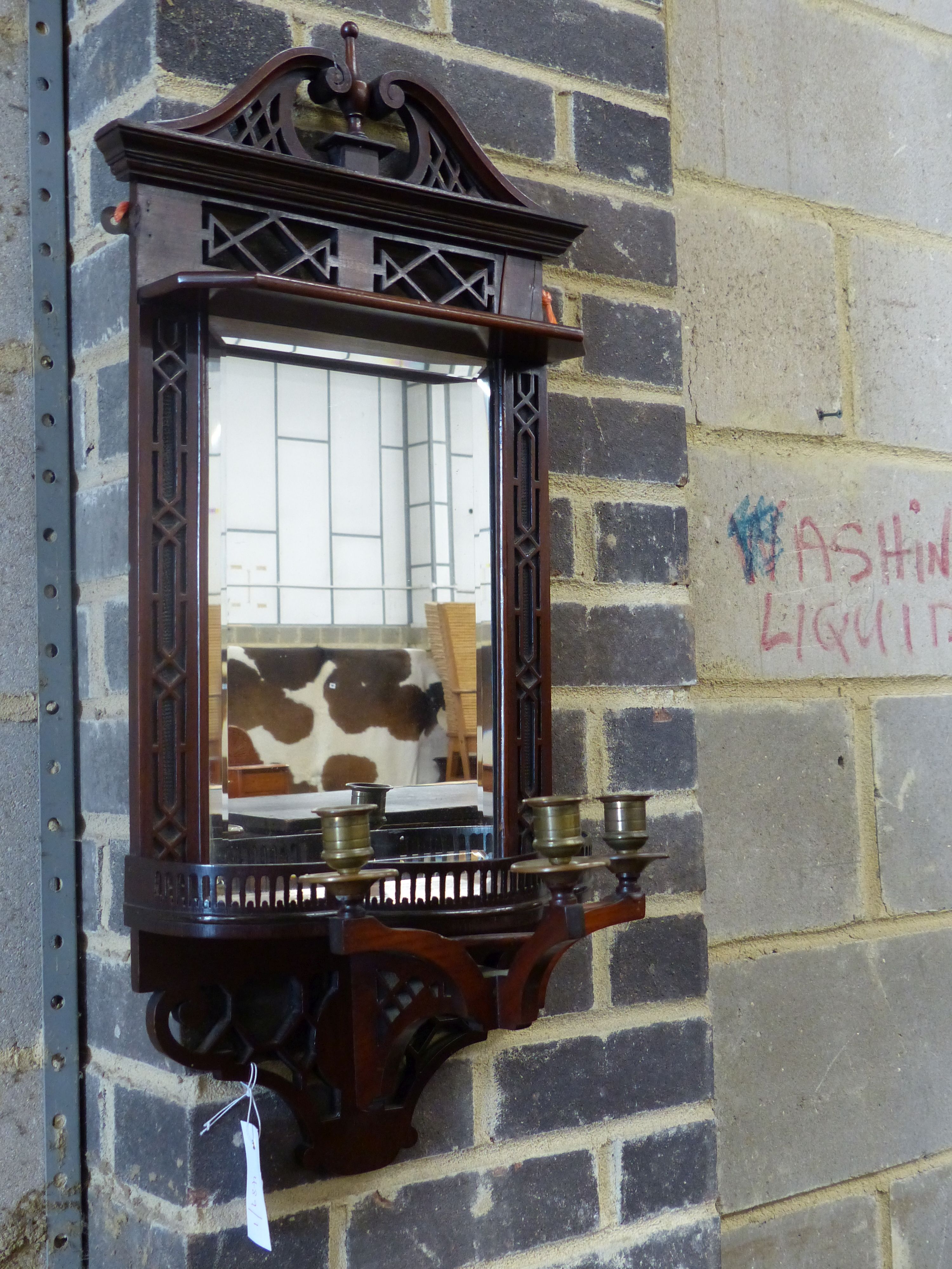 An Edwardian mahogany mirrored wall bracket with triple brass sconce, width 31cm height 75cm